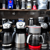 Various coffee machines displayed on a shelf from a coffee machine Supplier in Faridabad