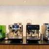 Three modern espresso machines brewing amazone coffee on a wooden counter in a cafe