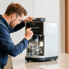 Man preparing espresso with sleek Atlantis coffee machine on kitchen counter