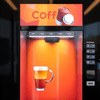 Modern coffee vending machine rental Noida with illuminated display and freshly brewed coffee cup