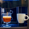 Freshly brewed coffee from a premix coffee vending service near me with a cup and glass waiting