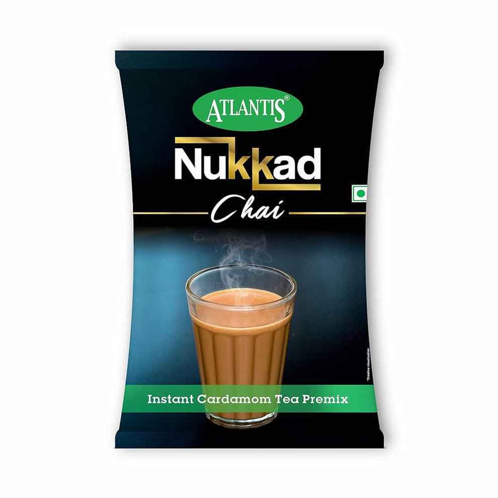 Atlantis Nukkad cardamom chai premix packet with steaming glass of instant cardamom tea