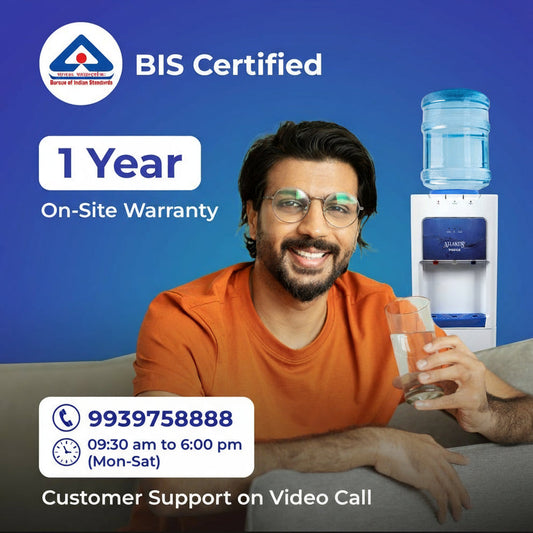 Smiling man with glass of water near Atlantis Prime water dispenser with BIS certification and one year warranty