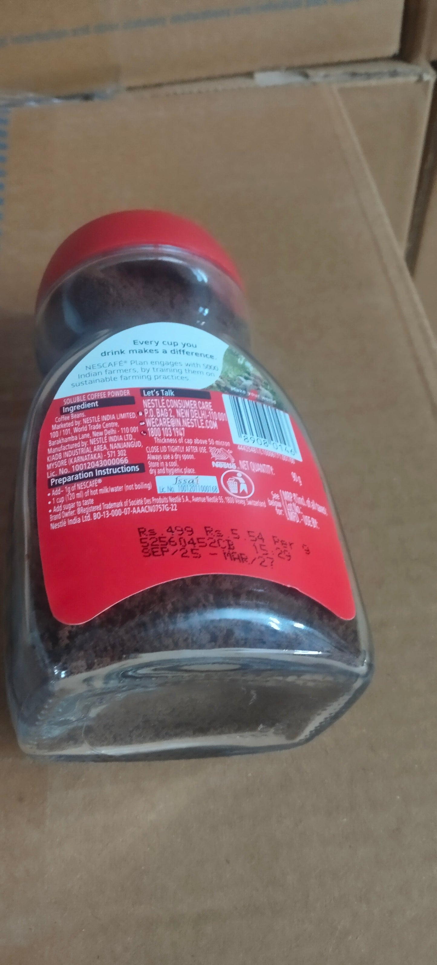 Glass jar of Nescafe Classic 90g coffee with red lid showing nutritional information on label