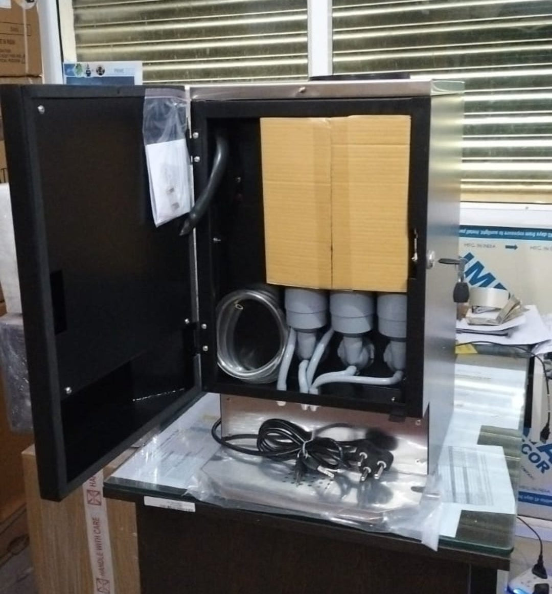 Open Nescafe smart coffee vending machine showing internal components and power cable