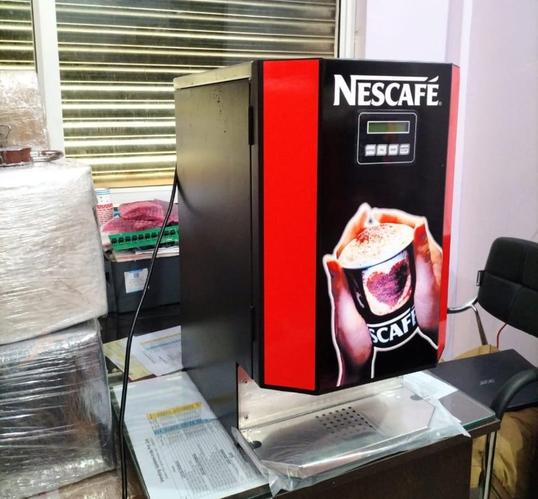 Nescafe vending machine with UPI payment option placed on a glass table in an office setting